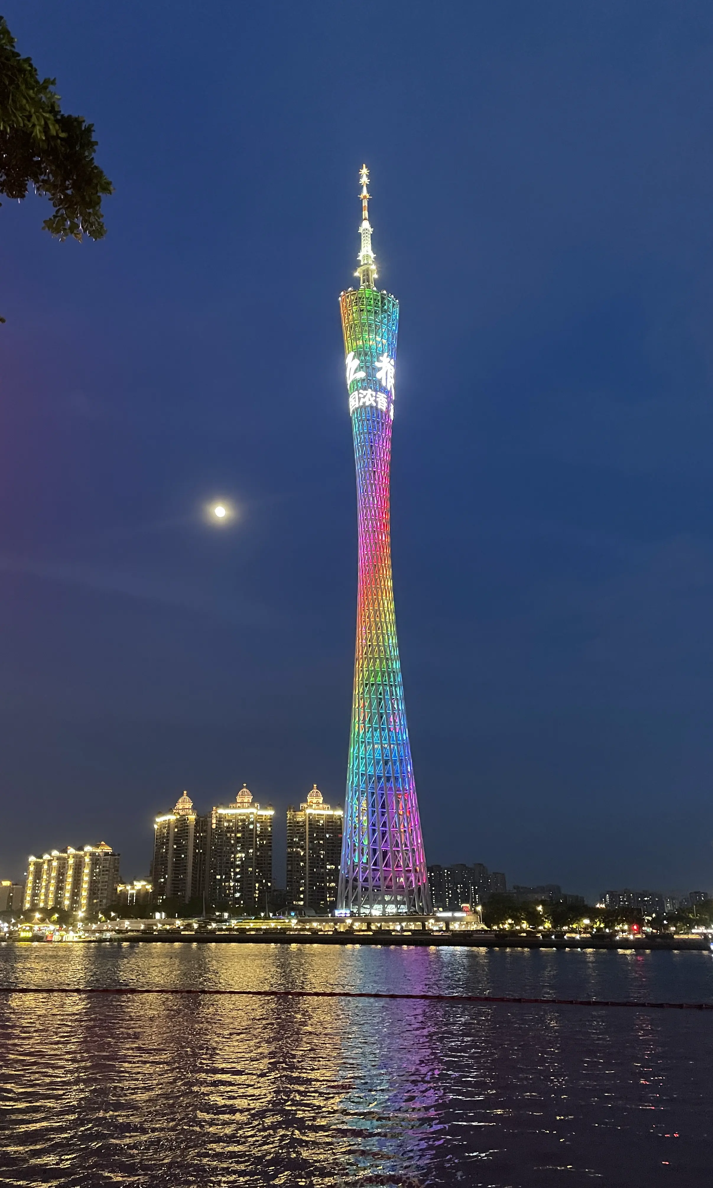 夜色中亮灯的广州塔、月亮与河面倒影