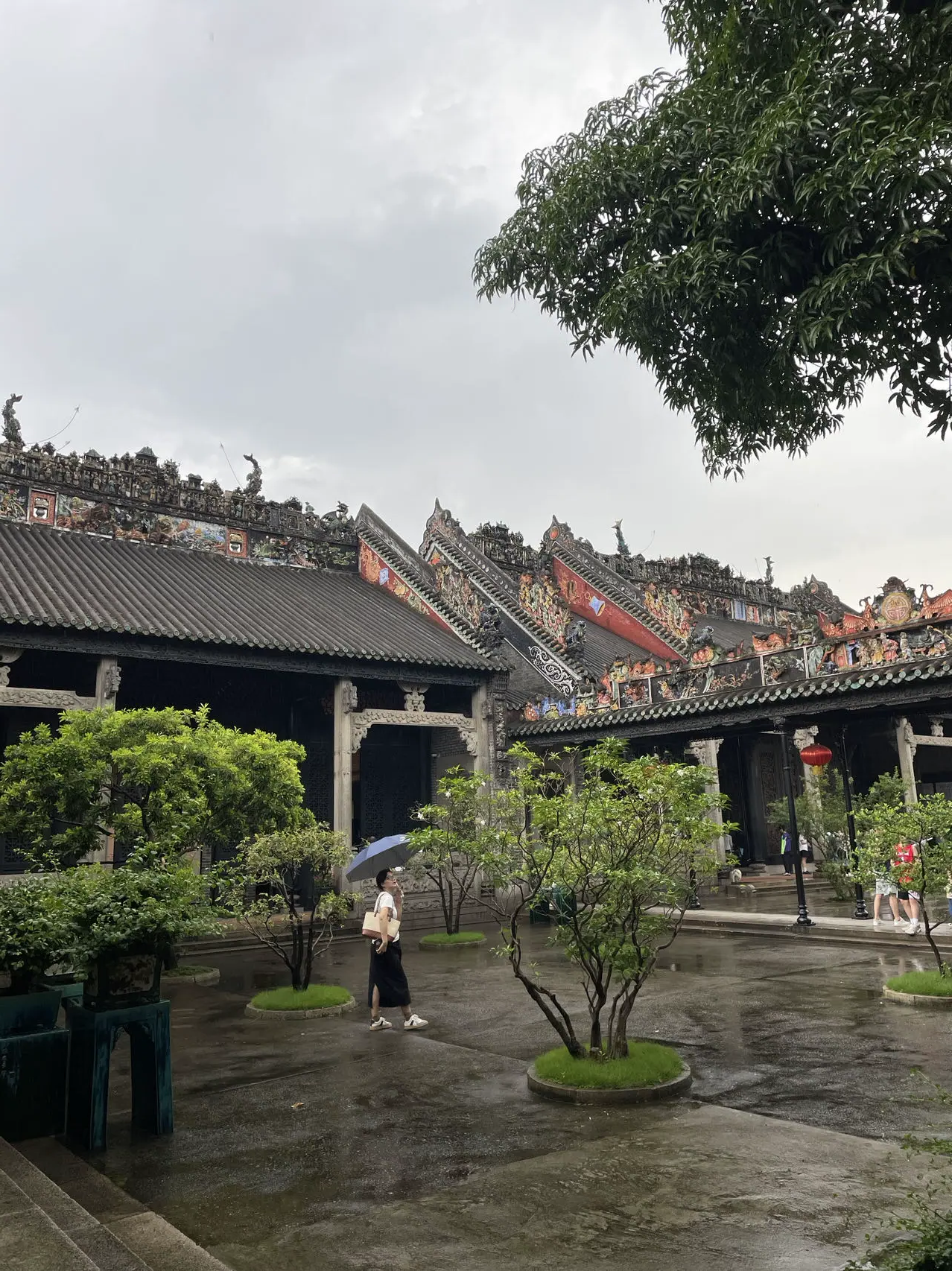 游客在陈家祠庭院中观看屋檐上的彩色装饰